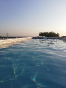 een zwembad met een strand op de achtergrond bij Casa Giufà B&B in Chiaramonte Gulfi
