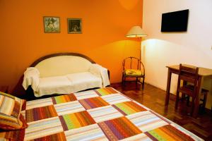 a bedroom with a bed and a desk and a table at Central Plaza Hotel Tupa in Tupã