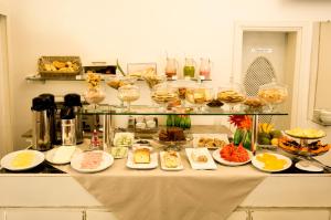 a table with many plates of food on it at Central Plaza Hotel Tupa in Tupã