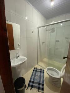 a bathroom with a shower and a toilet and a sink at Pousada Maciel in São Thomé das Letras +77 photos