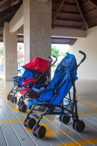 two strollers are lined up on a tiled floor at Princess Family Club Bavaro - All Inclusive in Punta Cana