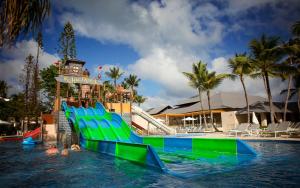a water slide in a pool with people in the water at Princess Family Club Bavaro - All Inclusive in Punta Cana