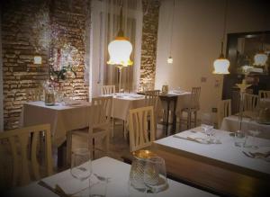 a restaurant with white tables and chairs and lights at Albergo Ristorante Palladio Osteria dal 1900 in Fratta Polesine
