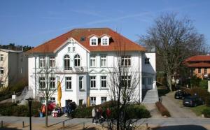キュールングスボルンにあるStrandstrasse-Wohnung-28-9408のオレンジ色の屋根の白い大きな建物