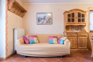 ein Wohnzimmer mit einem Sofa mit Kissen darauf in der Unterkunft Appartamento Serrada in Folgaria