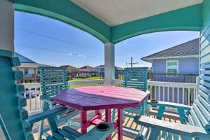 a table on the balcony of a house with chairs at Updated Crystal Beach Retreat with Deck and Fire Pit! in Bolivar Peninsula