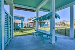 a blue bench on the porch of a house at Updated Crystal Beach Retreat with Deck and Fire Pit! in Bolivar Peninsula