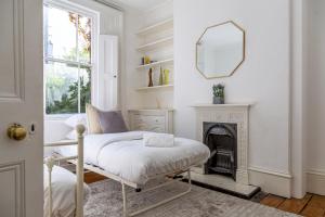 a white living room with a chair and a mirror at Amazing 5 Bed Victorian House - Clarence House in Birmingham