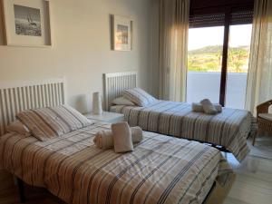 due letti uno accanto all'altro in una camera da letto di Apartamento en Magnifico Resort - Parque Botanico a Estepona Altre 57 foto