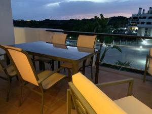 einen Tisch und Stühle auf einem Balkon mit Aussicht in der Unterkunft Apartamento en Magnifico Resort - Parque Botanico in Estepona