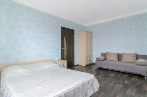 a bedroom with a bed and a couch at Квартира Лупшы 22 in Sumy