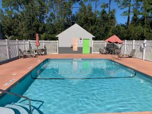une petite piscine avec des chaises et une clôture dans l'établissement Magnolia Inn Extended Stay of Kingsland - New 2023 - Book a Kitchen Room - 12 Noon Check Out - Sleep In Late - Better Sleep - Ultra Sparkling - Pool open until until 2AM - Stay and Save Today - 24 Hour Front Desk - Premium Coffee Bar - Award Winning Inn, à Kingsland
