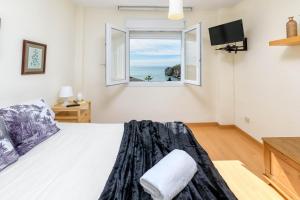 - une chambre avec un lit, une fenêtre et une télévision dans l'établissement WintowinRentals 1st Linea de playa vista al mar y piscina, à Cala del Moral