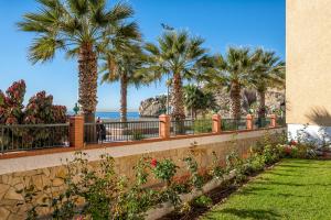 un mur de retenue avec des palmiers et la plage dans l'établissement WintowinRentals 1st Linea de playa vista al mar y piscina, à Cala del Moral