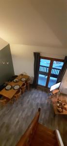 ein Esszimmer mit Tischen und Stühlen und einem großen Fenster in der Unterkunft L'Ourson skis aux pieds in Valmeinier