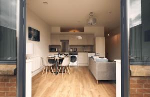 a kitchen and living room with a table and chairs at Herongate Apartments in Hungerford