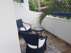 a balcony with two chairs and a table on a patio at Brisa do Mar Barê Praia Hotel - Praia de BAREQUEÇABA in São Sebastião