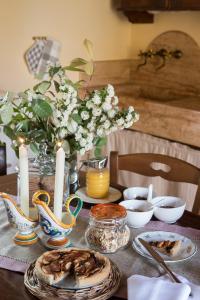 una mesa con velas y platos de comida. en Agriturismo Cretaiole, en Pienza