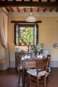 a dining room table with chairs and a window at Agriturismo Cretaiole in Pienza