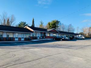 a building with cars parked in a parking lot at Bo-Mark Motel in North Bay