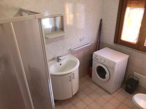 a bathroom with a sink and a washing machine at A casa di nonna Vituccia in Neviano