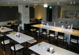 un restaurante con mesas y sillas blancas y un bar en Okadaya Bayside - Vacation STAY 00052v en Toyohashi