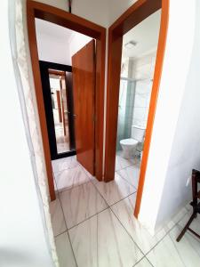 a bathroom with a mirror and a toilet at Apartamento Mirim Praia Grande in Praia Grande