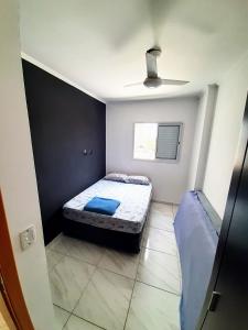 niewielka sypialnia z łóżkiem i oknem w obiekcie Apartamento Mirim Praia Grande w mieście Praia Grande