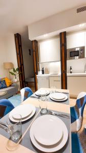 een eettafel met witte borden en stoelen bij Lindo Apartamento en zona centro, cerca de todo in Madrid