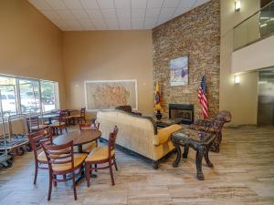 a living room with a couch and tables and chairs at Cherokee Grand Hotel in Cherokee