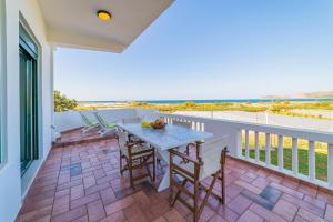 een terras met een tafel en stoelen op een balkon bij Villa Smaragdi - Private Sea View Villa in Falasarna +33 foto's