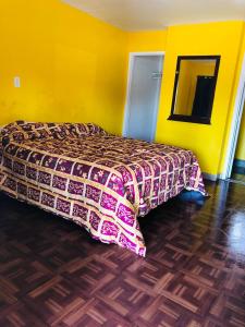 a bedroom with a bed and a yellow wall at Commodore Motel in Oakland