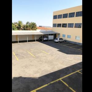 a parking lot in front of a building at Flip Palace Hotel in Buriti Alegre