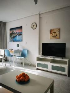 ベニドルムにあるSAN ANGELO Levante beach apartmentsのリビングルーム(薄型テレビ、テーブル付)