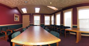 a conference room with tables and chairs and windows at Intown Inn & Suites in Merritt