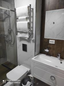 y baño con aseo, lavabo y ducha. en ЖОМАРТ, en Aktobe