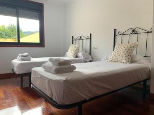 2 camas en una habitación con ventana en Oktheway Barro, en Barro