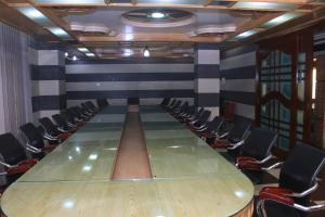 una sala de conferencias con una mesa larga y sillas en Naba Inn en Chittagong