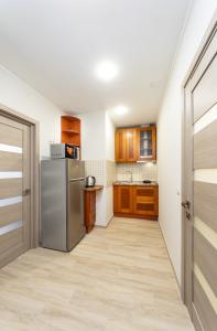 eine Küche mit einem Kühlschrank und Holzschränken in der Unterkunft Апартаменты Central Smart in Kiew