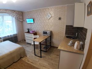 カリーニングラードにある117 улица Краснаяのベッド1台、デスク(シンク付)が備わる小さな客室です。