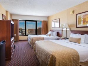 a hotel room with two beds and a large window at Ramada by Wyndham Topeka Downtown Hotel & Convention Center in Topeka +9 photos