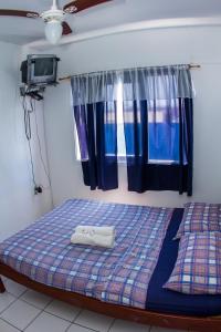 uma cama com duas toalhas num quarto em Hotel Recanto do Mar em Capão da Canoa