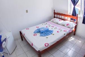 a bedroom with a bed with a stuffed animal on it at Hotel Recanto do Mar in Capão da Canoa