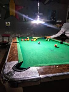a man is playing pool on a pool table at Social-Club La Cueva in Minas