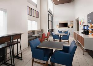 a restaurant with blue chairs and tables and a counter at Holiday Inn Express Hotel & Suites Olive Branch, an IHG Hotel in Olive Branch