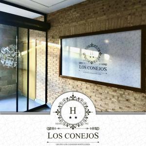 Hotel Los Conejos في Mora: علامة أمام نافذة متجر