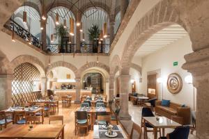 モレリアにあるHotel Herencia By Hosting Houseのテーブルと椅子が備わるレストランの内側の景色を望めます。