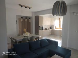 a living room with a blue couch and a table at Lavender and Sea in Nea Potidaea