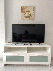 ベニドルムにあるSAN ANGELO Levante beach apartmentsの白いエンターテイメントセンターに座って薄型テレビを視聴できます。