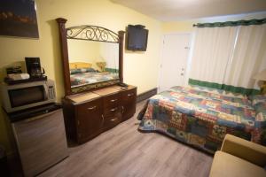 a bedroom with a bed and a mirror and a tv at Stardust Motel in Camrose